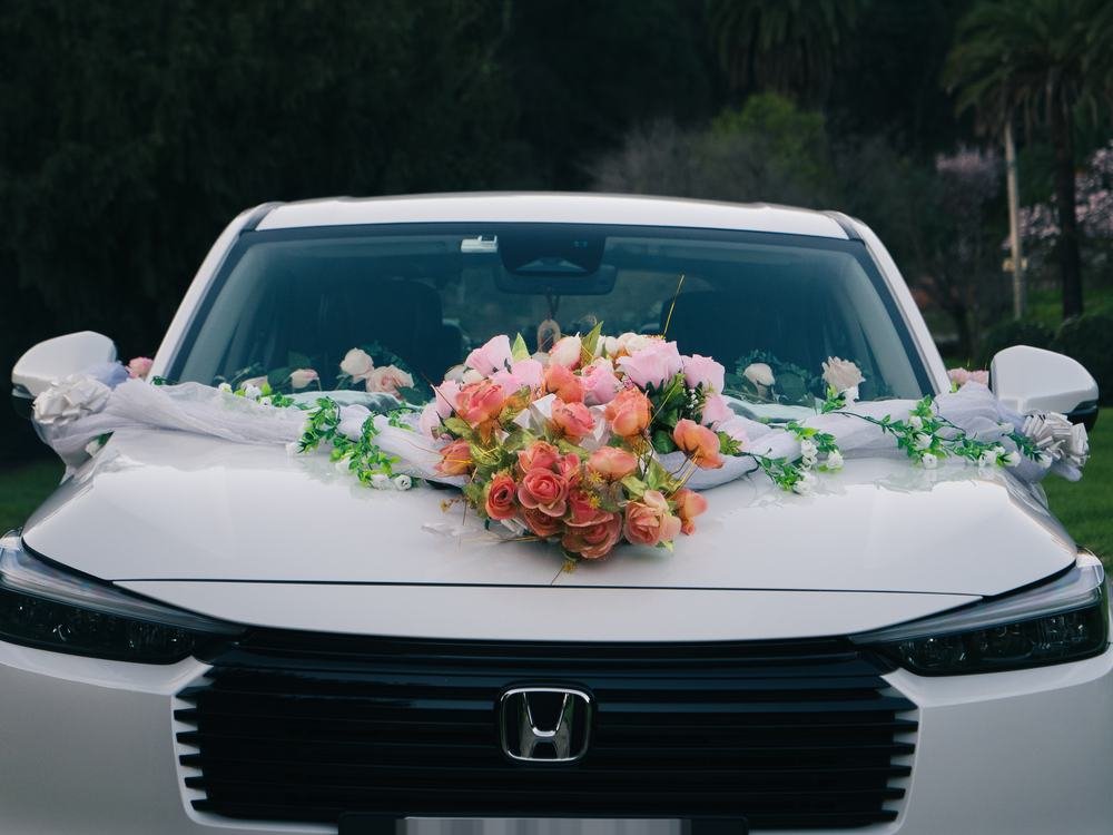 Detalle del ramo de flores sobre el capó, junto al logo del vehículo