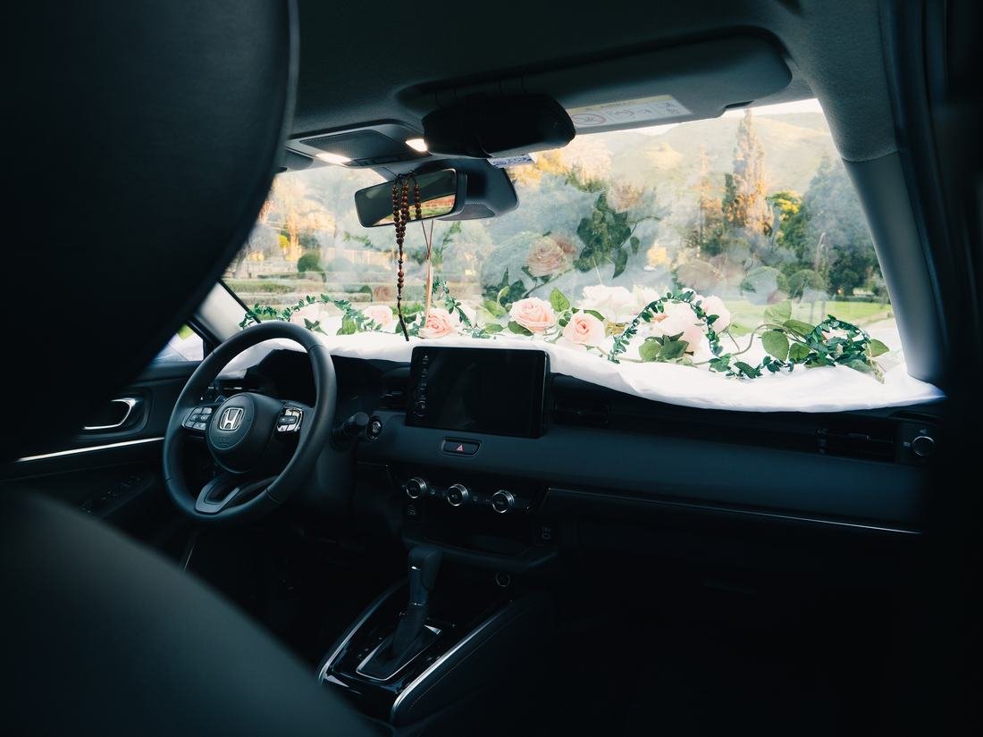 Interior del vehículo visto desde el tablero, con detalle floral